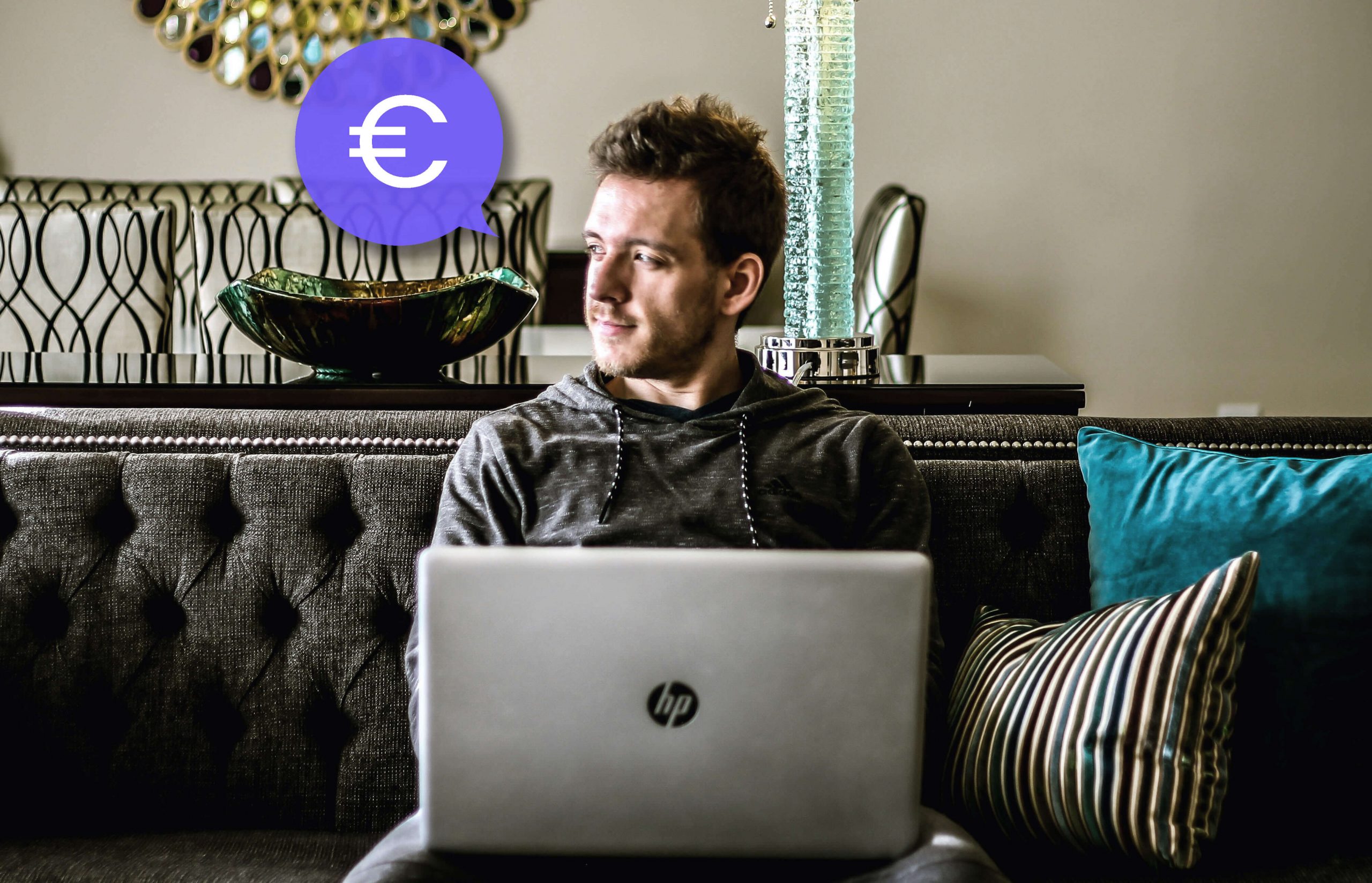 Mann sitzt auf der Couch mit seinem LapTop und denkt darüber nach, wie er von Zuhause aus Geld verdienen kann